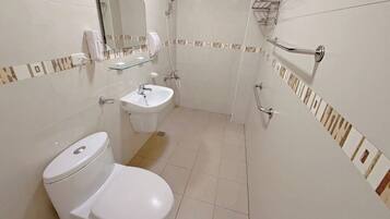 Une salle de bain avec des toilettes, un lavabo et une douche.