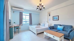 A bedroom with a bed, a desk, a chair, a sofa, and a coffee table. - Village Villa B&B (Zhuqi)