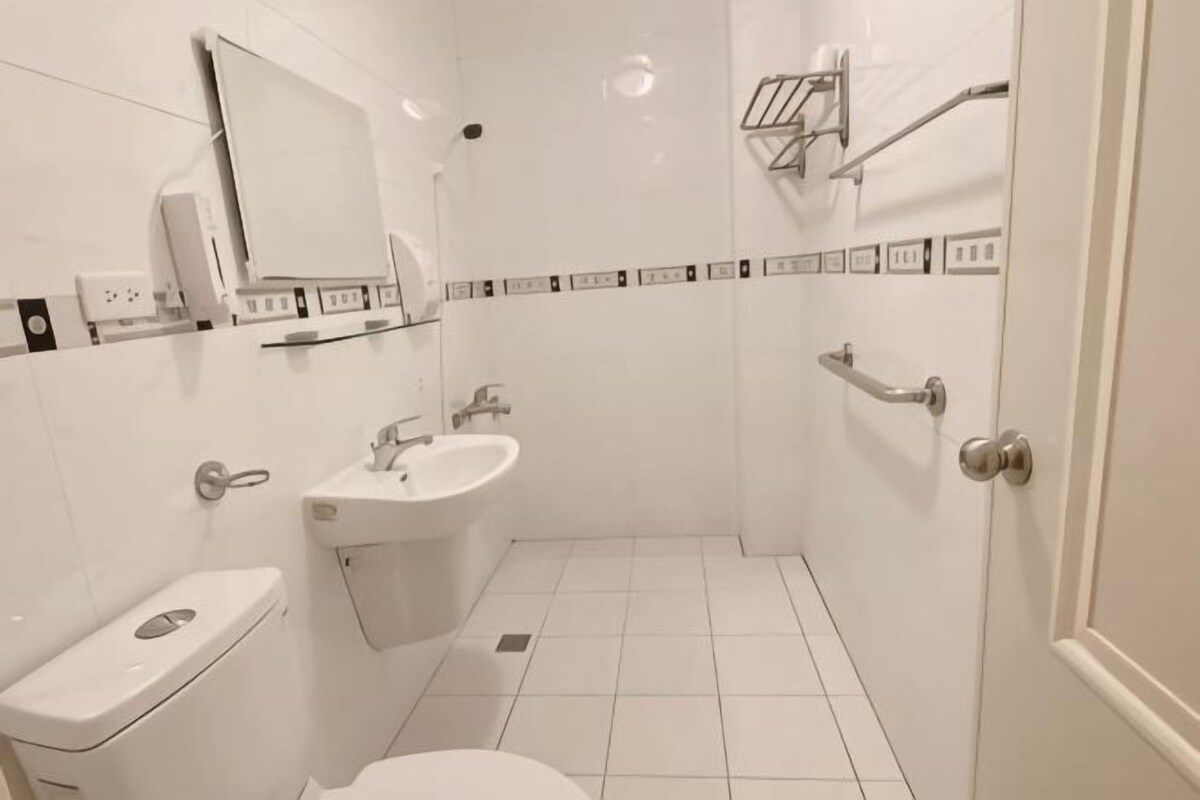 A small, clean bathroom with a toilet, sink, and mirror.