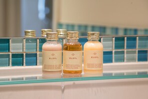 Three ELSYL bath and body products on a glass shelf.