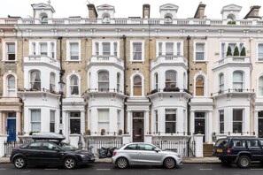 A row of terraced houses with white facades and bay windows.