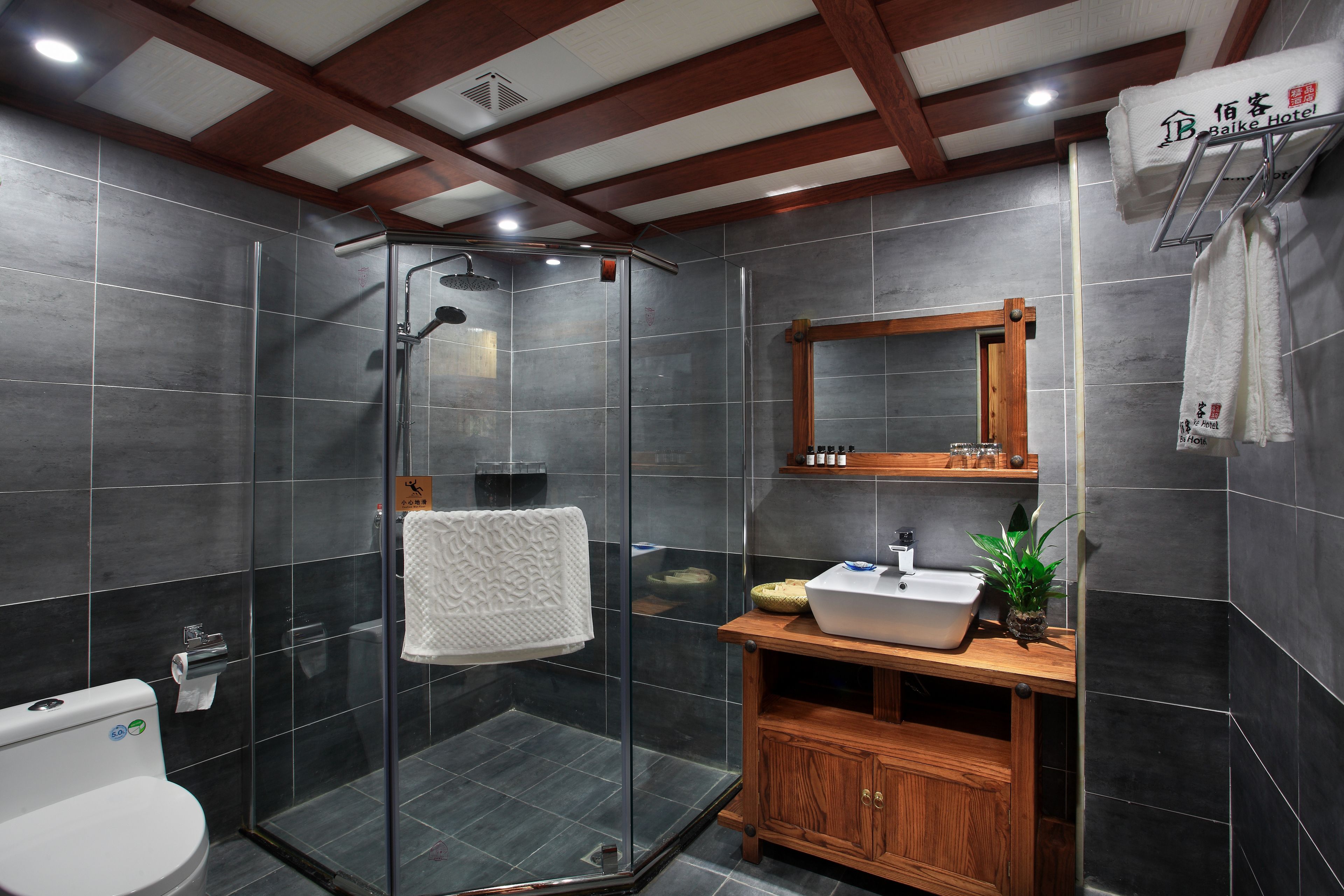 A modern bathroom with a glass-enclosed shower, a wooden vanity with a sink, and a mirror above it.