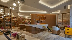 Una biblioteca moderna con una isla central, estanterías y zonas de estar.