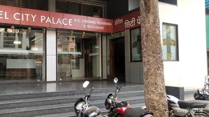 A hotel entrance with steps leading up to the doors, a Coca-Cola sign, and parked scooters. - Hotel City Palace (Nashik)