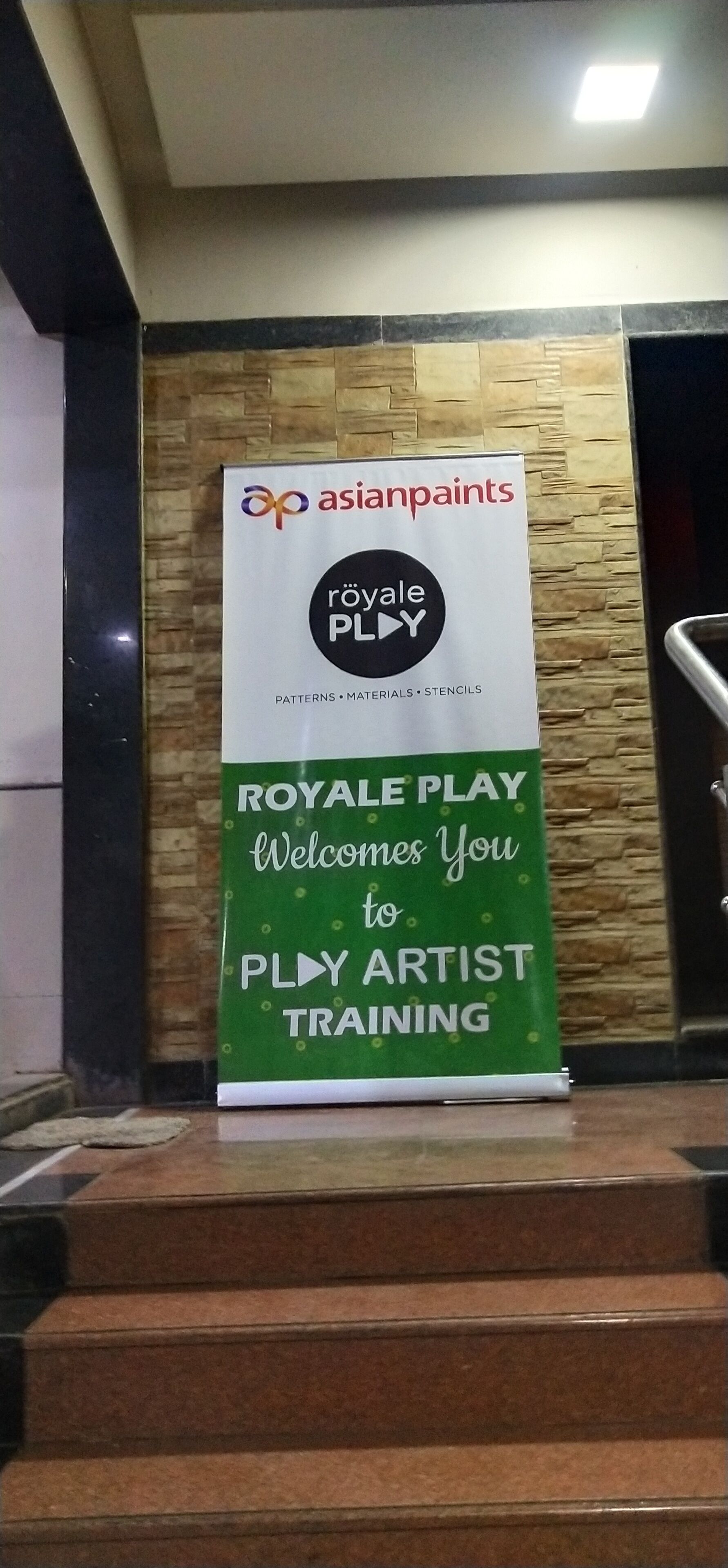 A sign for Royale Play artist training with a logo and text.