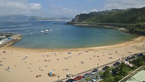 A beach with boats, a bridge, and a parking area. - Saiaz Getaria Hotela (Getaria)