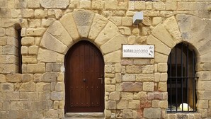 A stone building with a large wooden door and a sign for 'Sajazgetaria Hotel'. - Saiaz Getaria Hotela (Getaria)