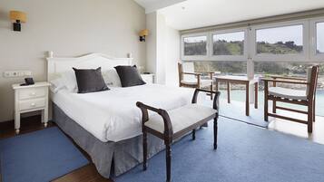 A bedroom with a large bed, bedside tables, a chair, and a view of the outdoors.