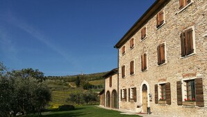A stone building with multiple windows and a well-maintained lawn. - Costa degli Ulivi (Fumane)