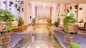 Eine geräumige Lobby mit Marmorboden, Sitzgelegenheiten und hängenden Pflanzen.