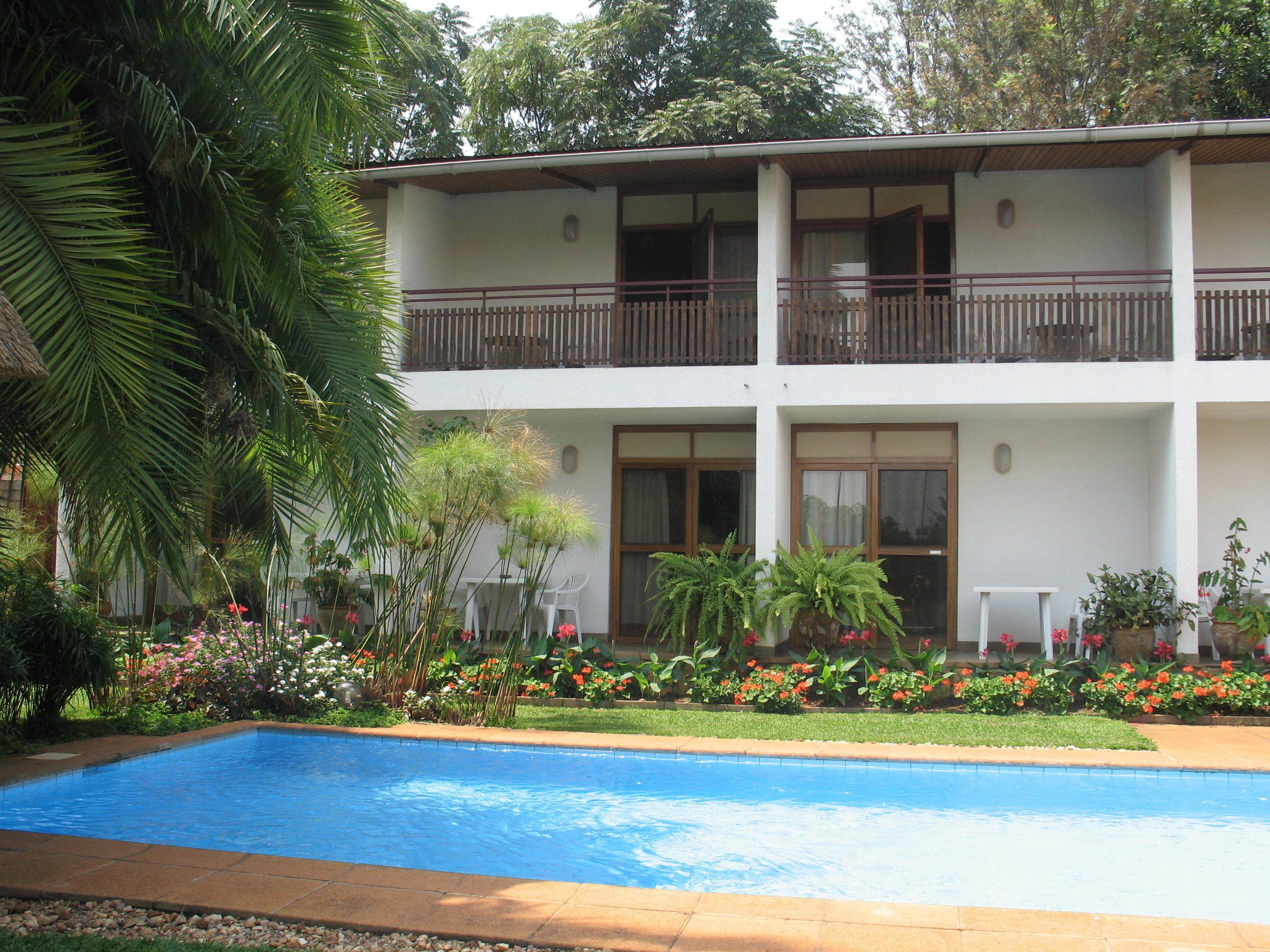 Un edificio de dos pisos con una piscina delantera.