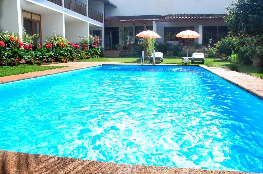 Een buitenzwembad, parasols voor strand/zwembad