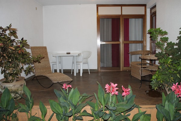 A room with a dining table and chairs, a potted plant, and a window with curtains. - Hotel Le Garni Kigali (Kigali)