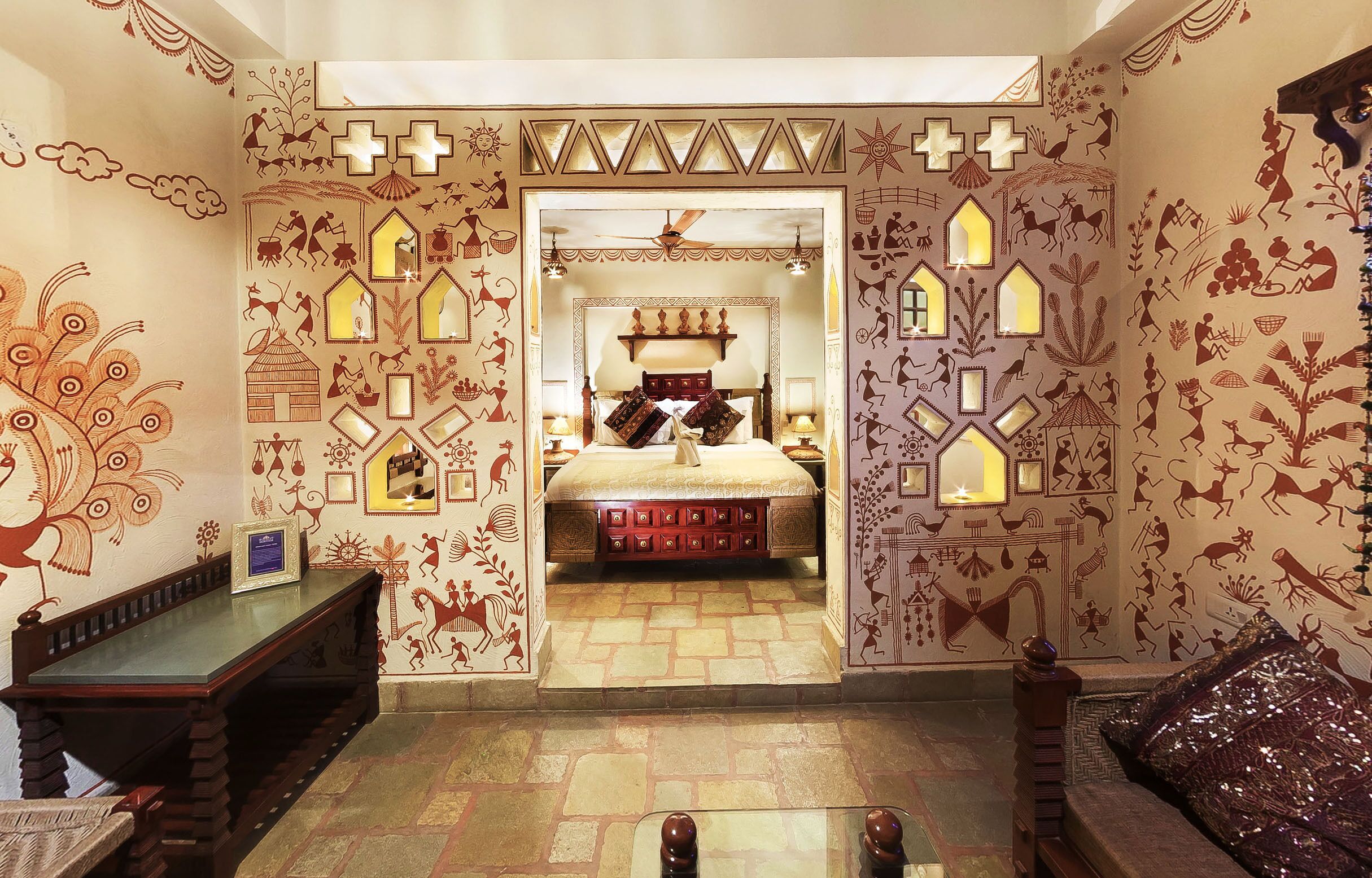 A traditional room with a bed, a wooden bench, and a sofa.