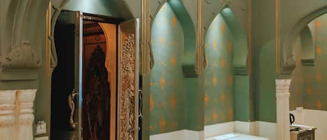 A room with a patterned floor, a statue, and a decorative ceiling.