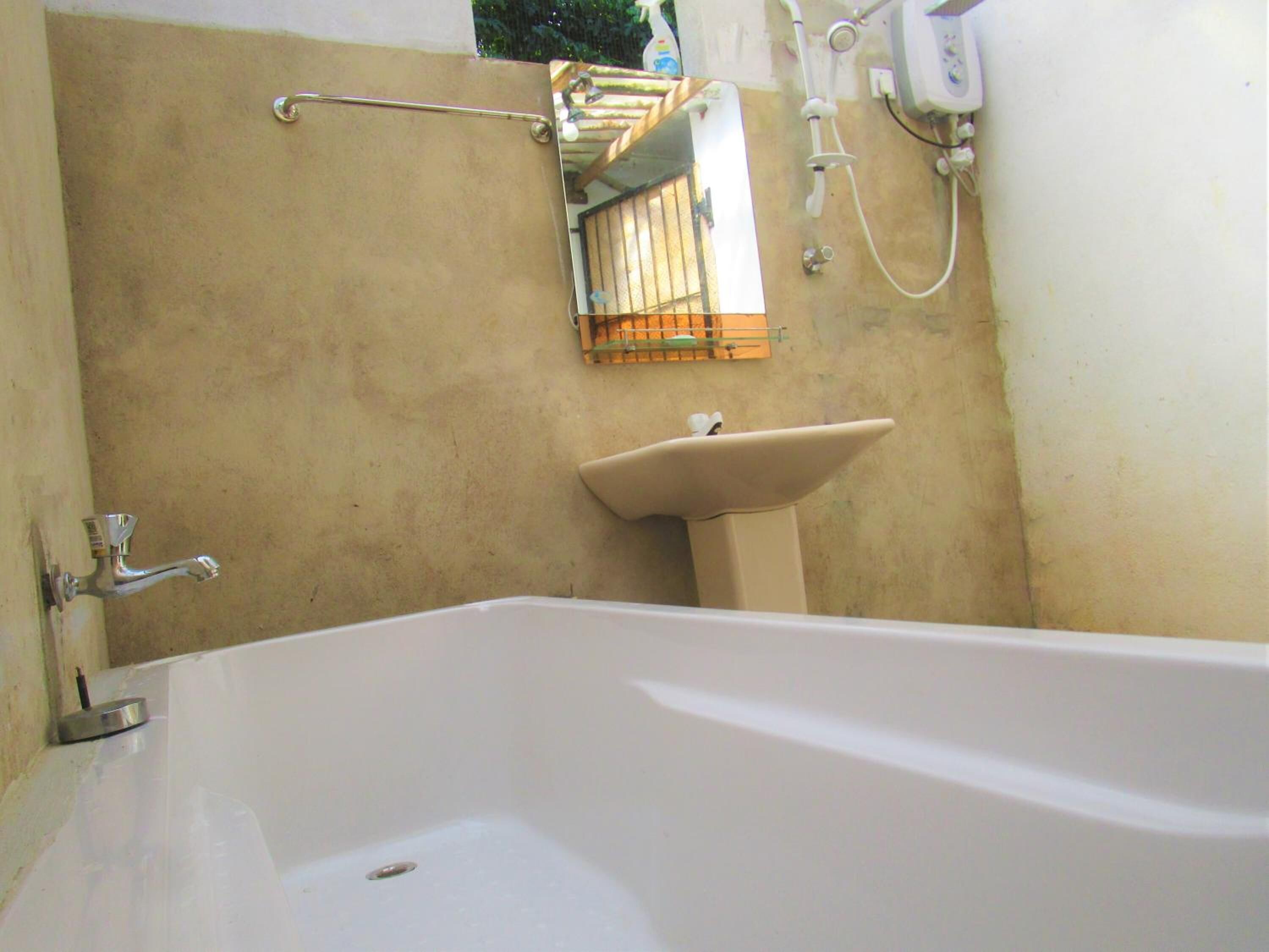 Une salle de bain avec une baignoire, un lavabo et un espace douche.
