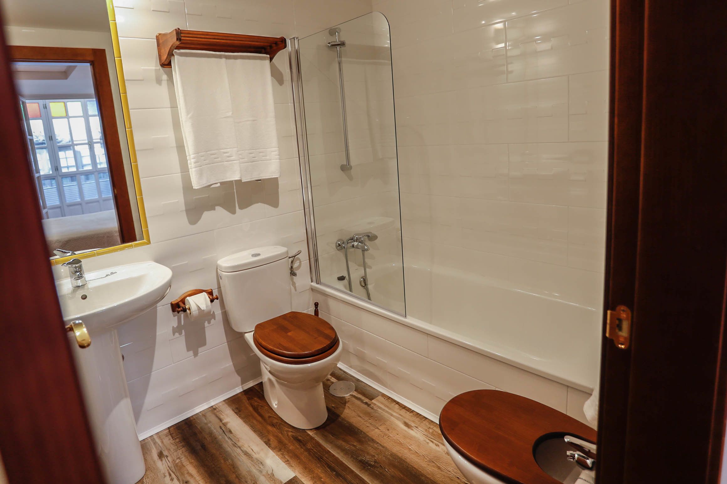 A bathroom with a toilet, sink, and shower.