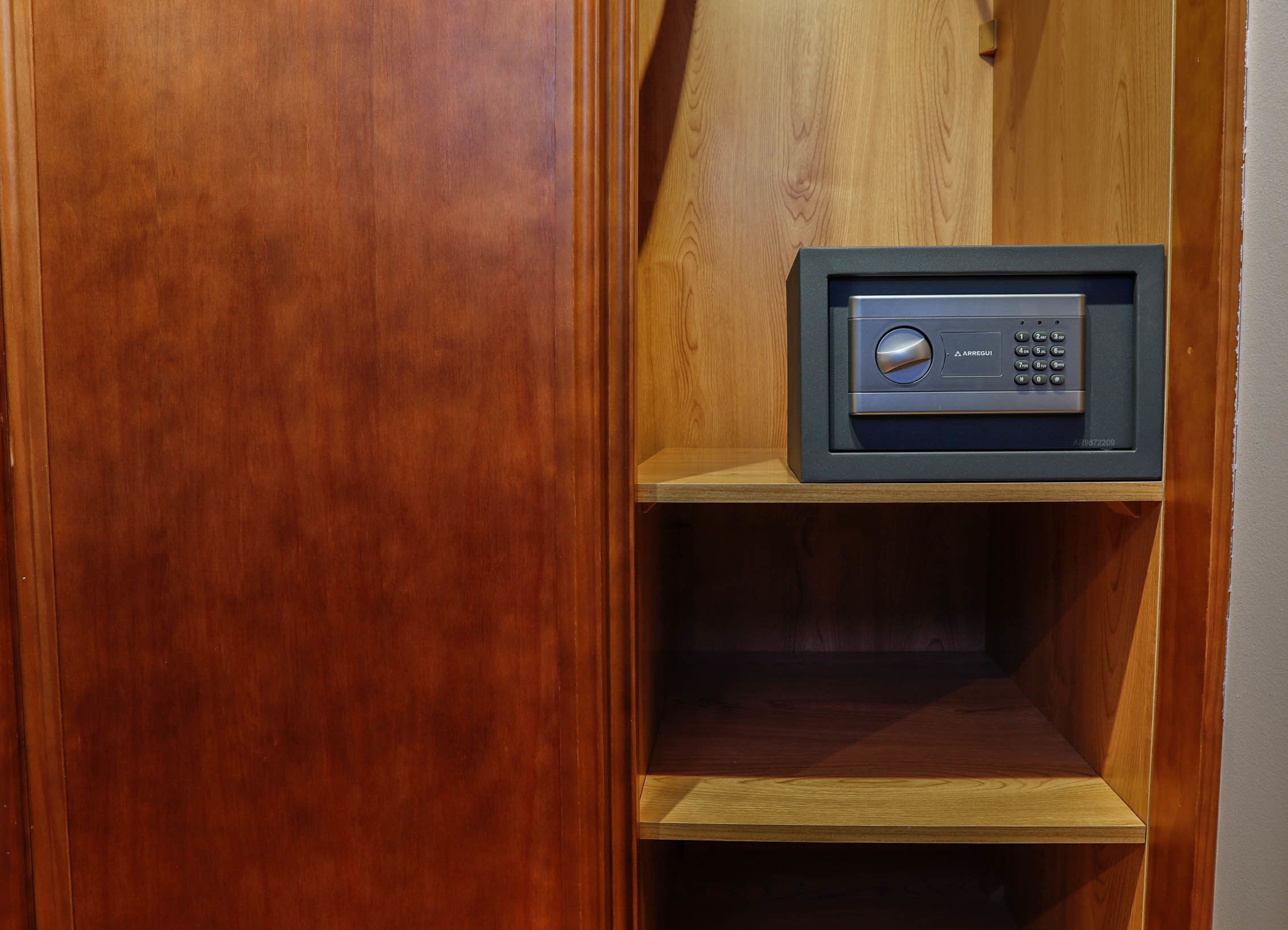 Un mueble de madera con un microondas integrado en la repisa superior.