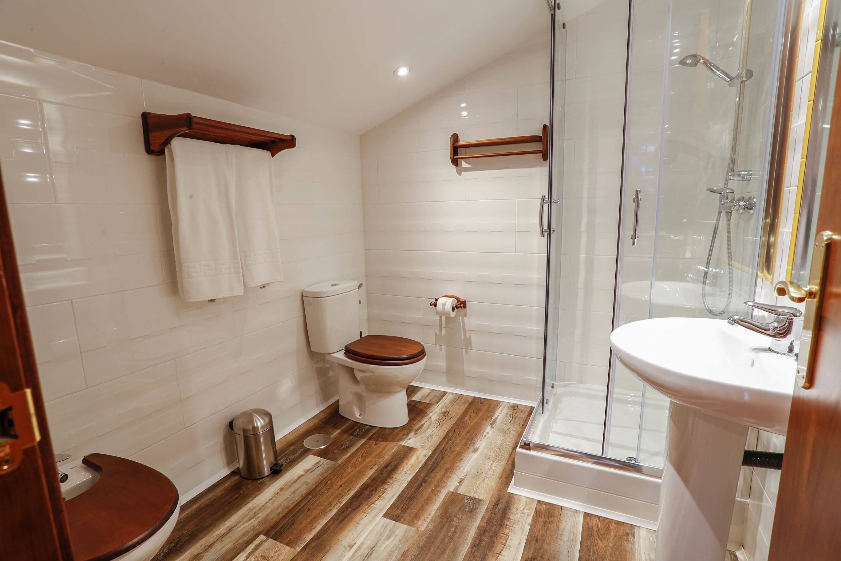 Un baño con inodoro, bidé y zona de ducha con mampara de cristal.