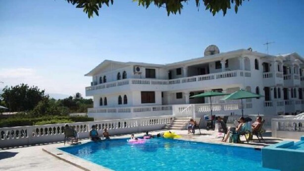 Une grande piscine avec un bâtiment blanc en arrière-plan.