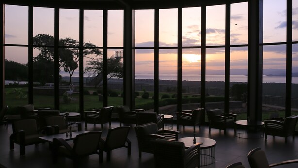 A terrace with multiple tables and chairs, overlooking a scenic landscape with trees and a distant view of the horizon. - Haile Resort Arbaminch (Arba Minch)