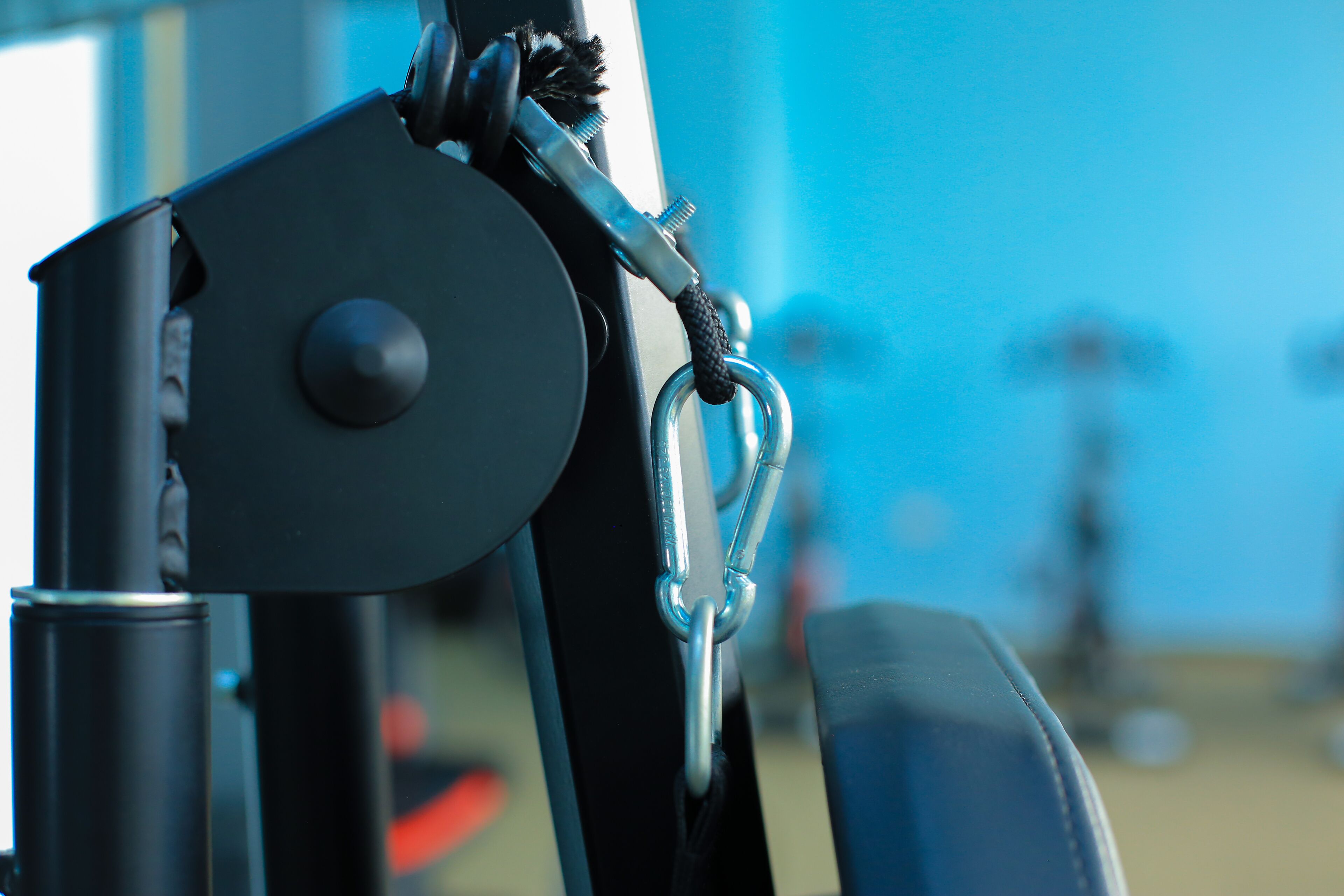 A close-up of a mechanical device with a metal ring and a black rope.