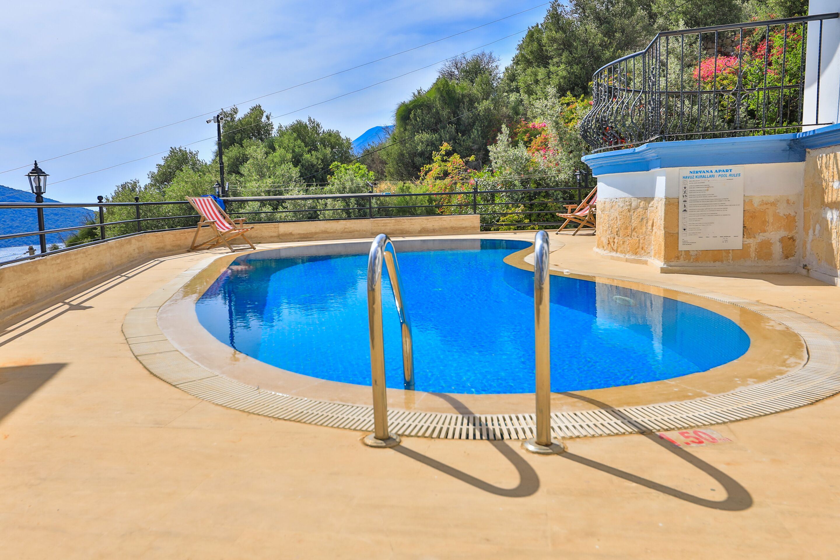 A pool with metal railings, a flag, and a sign.