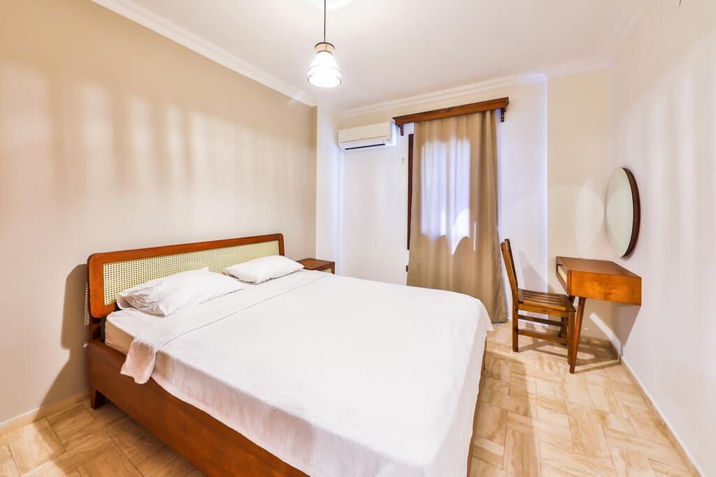 Ein Schlafzimmer mit einem hölzernen Bett, einem Schreibtisch und einem Stuhl.