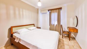 Un dormitorio con una cama de madera, un escritorio y una silla.