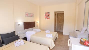 Una camera d'albergo con due letti, una testiera in legno, una scrivania e un'area pranzo con un vassoio di cibo.