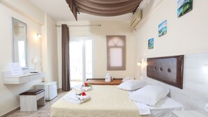 A hotel room with a bed, bedside table, mirror, and a view of the outside. - Summer Beach Hotel (Kassandra)