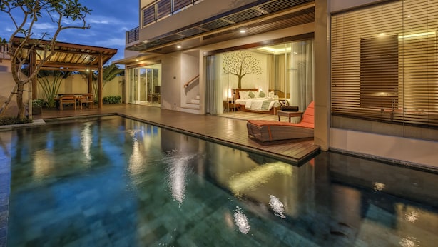 A modern house with a swimming pool, a covered patio, and a bedroom with a large bed and a tree mural. - The Miracle Villas Nusa Dua (Nusa Dua)