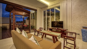 A modern living room with a sofa, chairs, a coffee table, and a TV. - The Miracle Villas Nusa Dua (Nusa Dua)