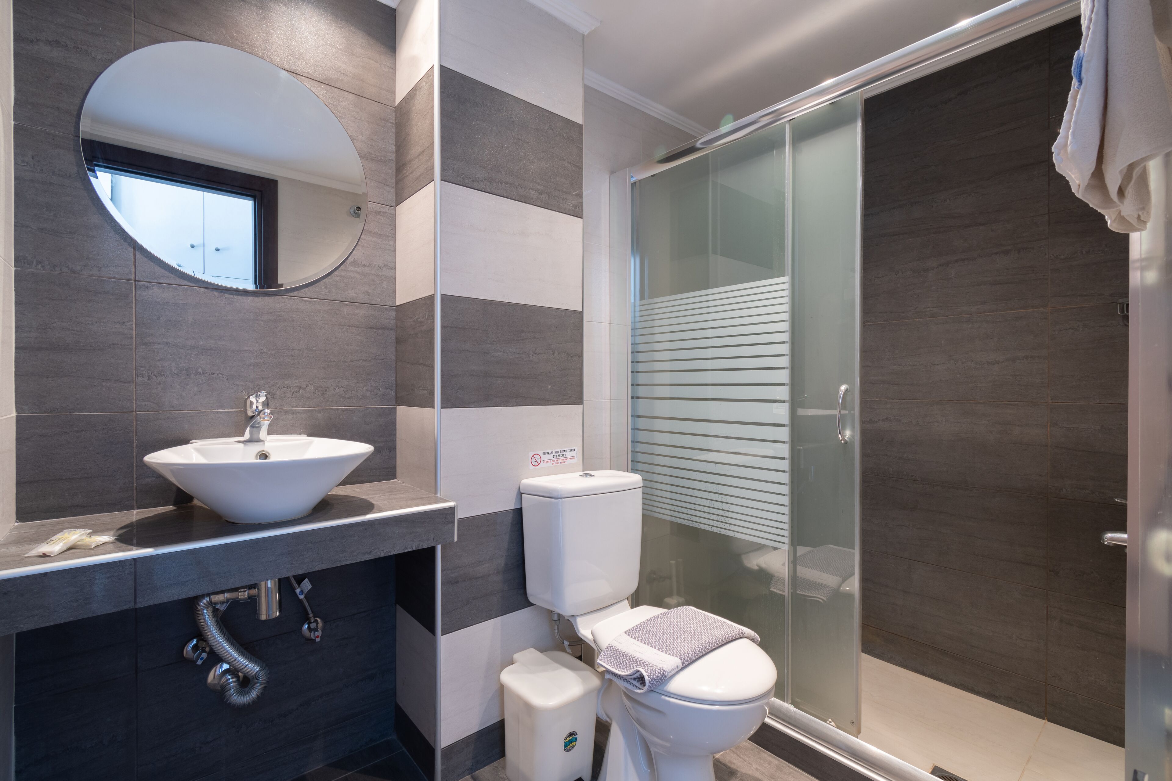 Un baño moderno con lavabo, inodoro y cabina de ducha de vidrio.