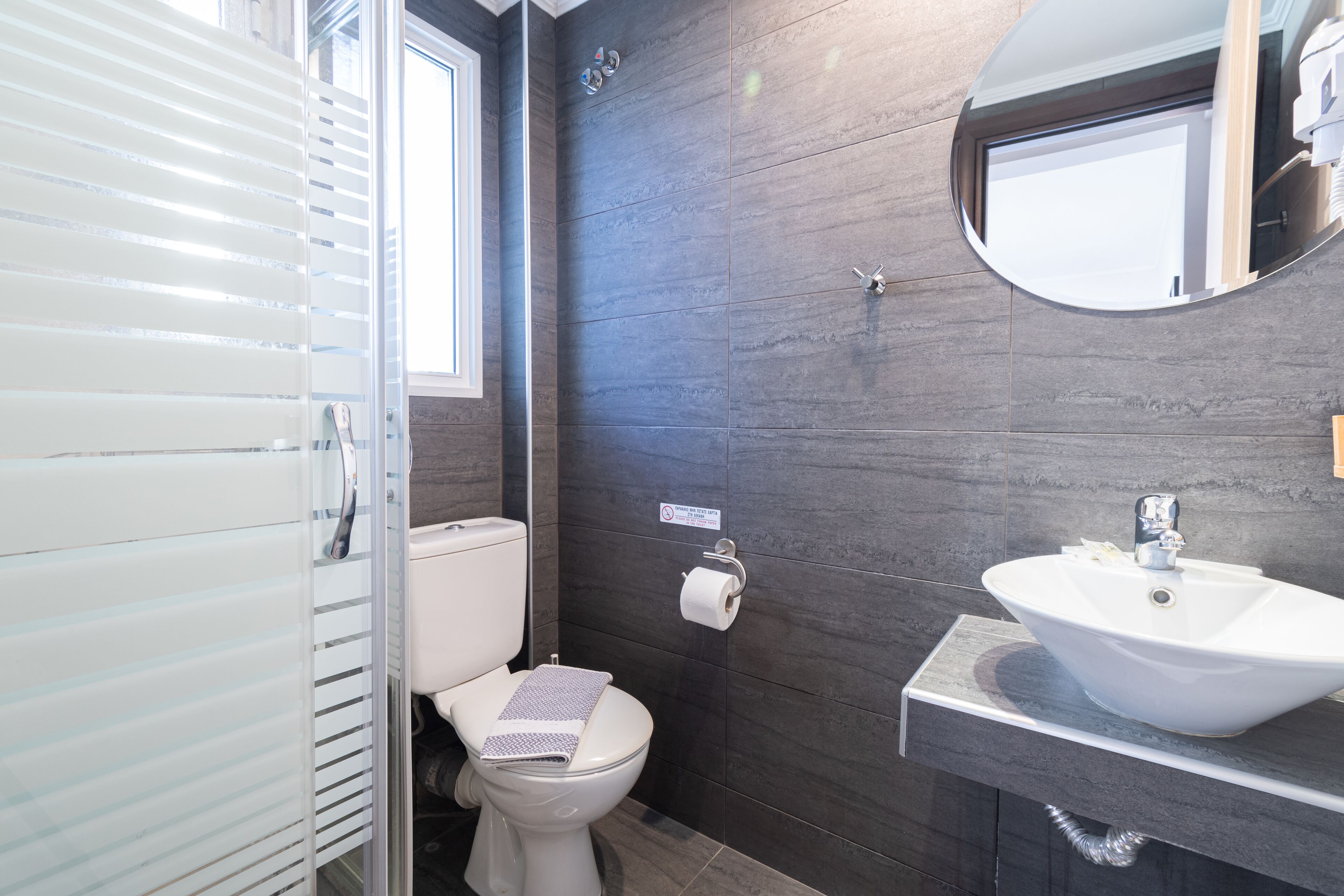 A modern bathroom with a toilet, a sink, and a mirror.