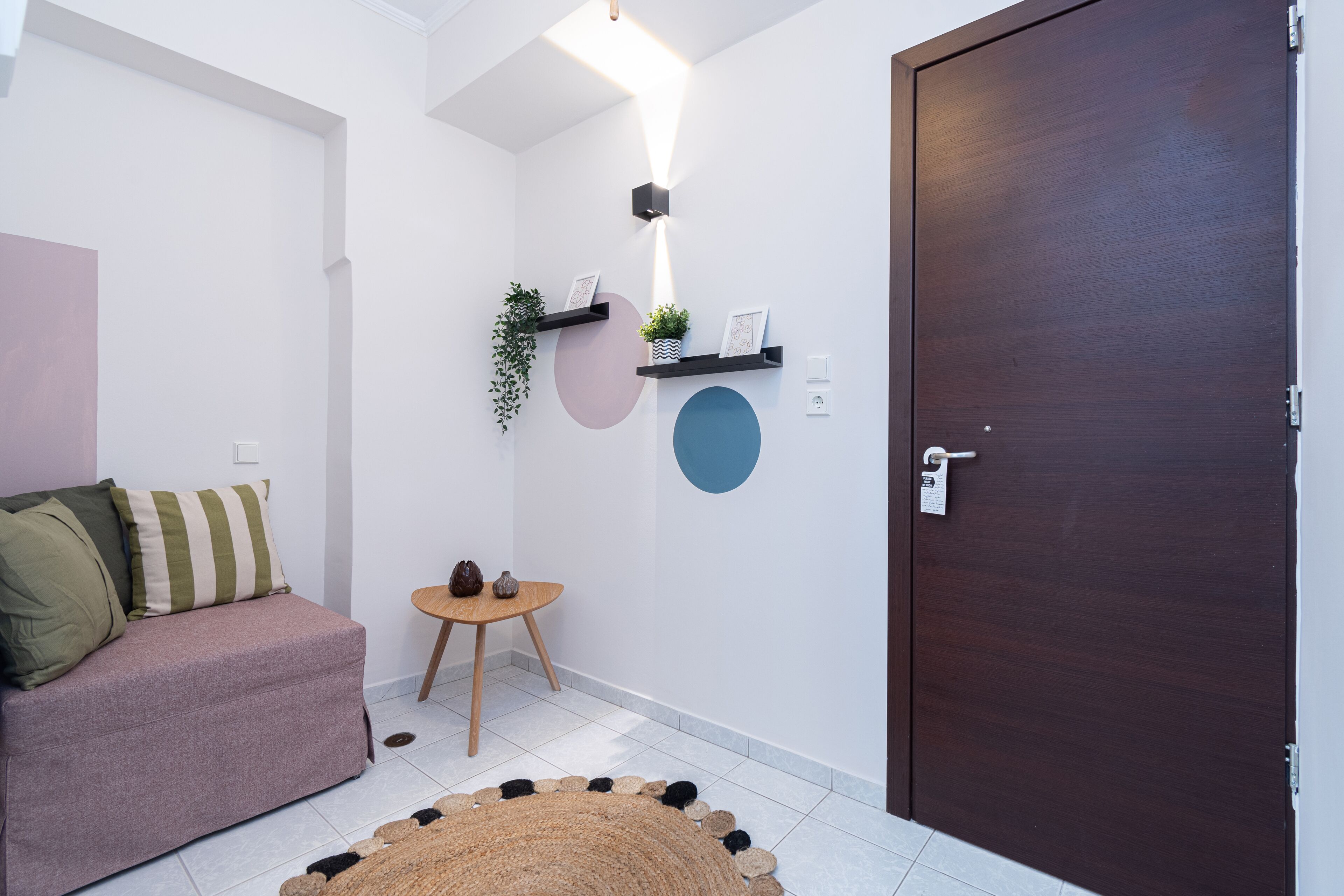 Een moderne woonkamer met een bank, een klein houten tafeltje en een rond vloerkleed.