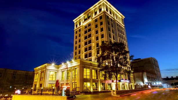 Ein mehrstöckiges Hotel mit einer markanten Fassade, großen Fenstern und guter Beleuchtung.