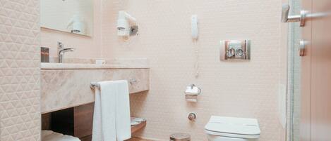 Un baño moderno con ducha, inodoro y tocador.