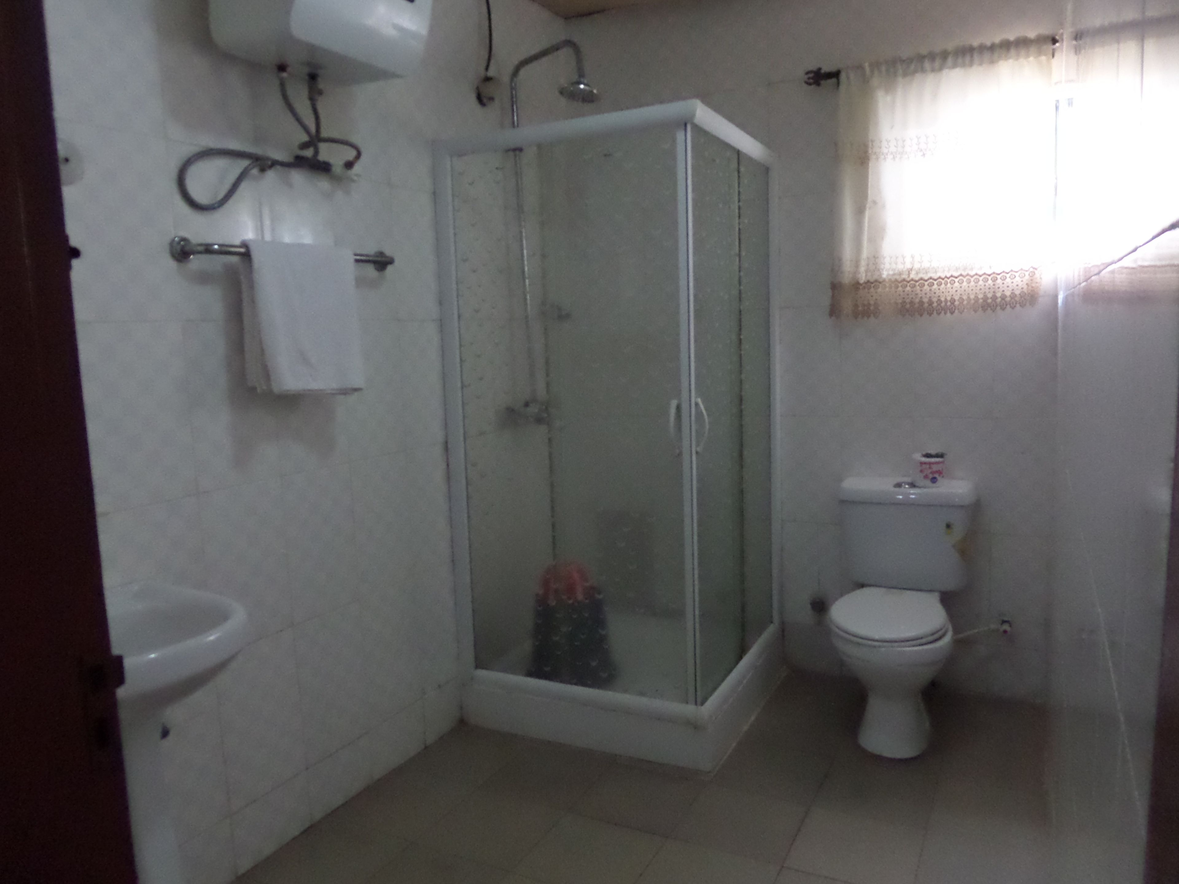 Une salle de bain avec une douche à parois de verre, des toilettes et un lavabo.