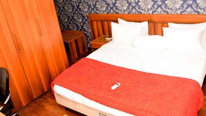 A neatly made bed with a red blanket, a wooden headboard, and white pillows. - Koza Apartment (Lagos)