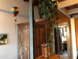 Una habitación con un armario de madera, una planta colgante y una decoración de globo aerostático colorido.