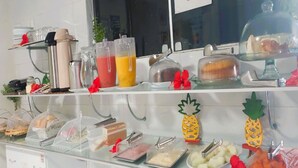 A buffet setup with various food items and beverages. - Pousada Sao Silmares (Fernando de Noronha)