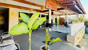 A covered outdoor area with a sign reading 'Pousada São Silvério,' potted plants, and outdoor seating. - Pousada Sao Silmares (Fernando de Noronha)