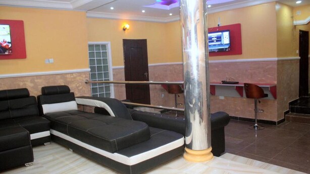 Un lobby moderno con un sofá seccional, una zona de bar y un pilar grande.