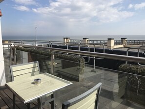 Enjoy a serene dining or relaxation experience on this outdoor space with a glass balustrade overlooking the water.