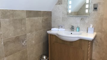 Une salle de bain avec un lavabo blanc, un meuble en bois et un miroir.