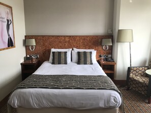 Relax in comfort with a large bed, two bedside tables, and a cozy chair.