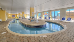 An indoor swimming pool with a central statue, sun loungers, and a tiled floor. - Camelot by the Sea by Elliott Beach Rentals (Myrtle Beach)