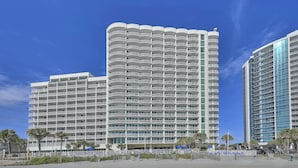 Un hotel alt amb nombroses galeries, vistes a la platja i un disseny arquitectònic modern.