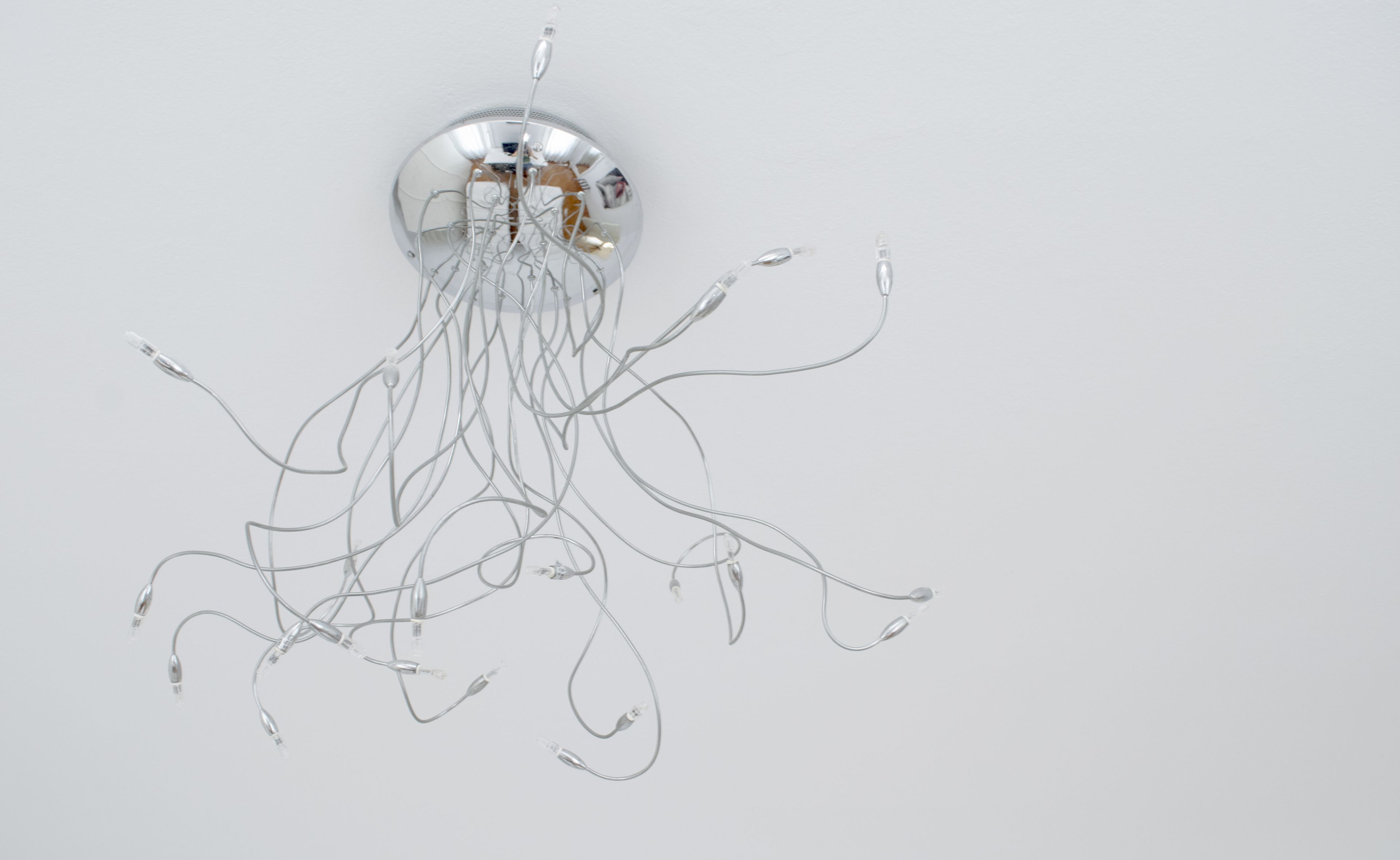 A ceiling light fixture with multiple wires and bulbs.